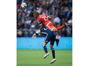 New England Revolution's Jose Goncalves, top, jumps over the back of Vancouver Whitecaps' Blas Perez to get to the ball during second half MLS soccer action in Vancouver, B.C., on Saturday June 18, 2016. THE CANADIAN PRESS/Darryl Dyck ORG XMIT: VCRD114