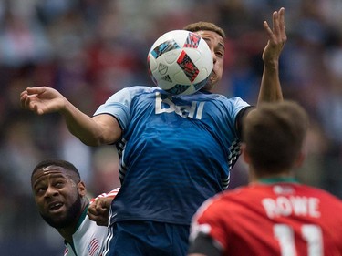Vancouver Whitecaps' Erik Hurtado, centre, traps the ball with his chest as New England Revolution's Andrew Farrell, left, watches during first half MLS soccer action in Vancouver, B.C., on Saturday June 18, 2016. THE CANADIAN PRESS/Darryl Dyck ORG XMIT: VCRD112