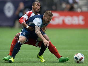 New England Revolution's Teal Bunbury, left, ties up Vancouver Whitecaps' Jordan Harvey during first half MLS soccer action in Vancouver, B.C., on Saturday June 18, 2016. THE CANADIAN PRESS/Darryl Dyck ORG XMIT: VCRD111