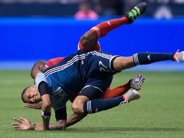 Vancouver Whitecaps' Blas Perez, front, and New England Revolution's Jose Goncalves collide after Goncalves jumped over Perez's back to get to the ball during second half MLS soccer action in Vancouver, B.C., on Saturday June 18, 2016. THE CANADIAN PRESS/Darryl Dyck ORG XMIT: VCRD115