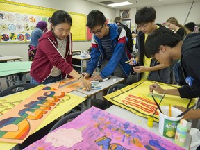 Grade 9 students at Guildford Park Secondary make signs for Monday's Pride Prom.