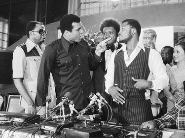FILE - In this July 17, 1975, file photo, heavyweight champion Muhammad Ali, left, points at challenger Joe Frazier at a news conference in New York City. Standing between the fighters is boxing promoter Don King. It was, Muhammad Ali would later say, the closest thing to death he had ever known.  He and Joe Frazier had gone 14 brutal rounds in stifling heat off a Philippines morning before Frazier's trainer Eddie Futch mercifully signaled things to an end, his fighter blind and battered and feeling pretty close to death himself. It was 40 years ago and the ``Thrilla in Manillaíí still lives in sporting lore. (AP Photo/File)