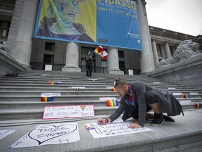 Chad Walters helps prepare for a vigil outside the Vancouver Art Gallery Sunday to pay tribute to people killed in an Orlando, Fla., nightclub earlier in the day. At least 50 people were killed and more than 50 others wounded when a gunman opened fire and took hostages at a gay nightclub. Mark van Manen/PNG