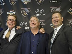 Jason McKee, right, named as the new head coach of the Vancouver Giants in Vancouver on Thursday, stands with team owner Ron Toigo, centre, and new GM Glen Hanlon.