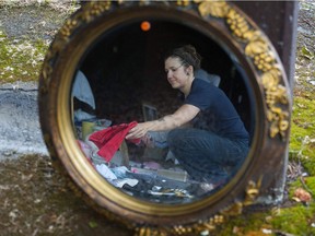 Damp weather didn't deter buyers and sellers at yard and garage sales near Commercial Drive in Vancouver on Saturday. Pictured is seller Johanna Ekdahl sorting clothes at a garage sale on E. 3rd Avenue. Ekdahl is reflected in a mirror, one of the items up for sale.