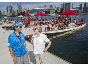 Race director Greg Lamb, left and general manager of the Canadian International Dragon Boat Festival Ann Phelps talk at False Creek in Vancouver on Sunday. Race organizers had asked owners of boats to move to west of the Cambie Street bridge during the Dragon Boat festival.