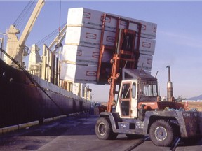 A forklift puts a load of lumber from CanFor on to a ship in Vancouver harbour in this undated handout photo.