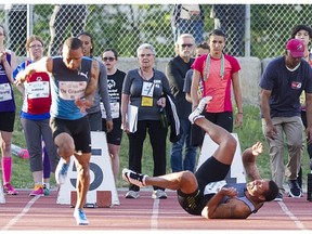 Andre De Grasse ( L ) leaves the blocks as Ryan Bailey ( R ) falls in the 100m compete in the Vancouver Sun Harry Jerome International Track Classic.