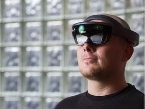 Hammer & Tusk leader Mack Flavelle wears a set of HoloLens at Hammer & Tusk's virtual reality and interactive media studio in Vancouver.