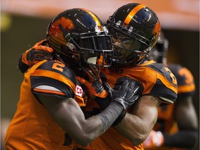 Lions Chris Rainey, left, and Keynan Parker celebrate Rainey's TD against the Calgary Stampeders Saturday night at B.C. Place.