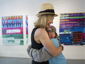 Franke James (L) gives sister Teresa Pocock a hug at Gallery Gachet, where Pocock is mounting an exhibit of her artwork.