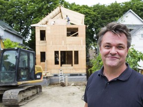 Michael Bruce poses for a photo in front of an old character home he is restoring in Vancouver.