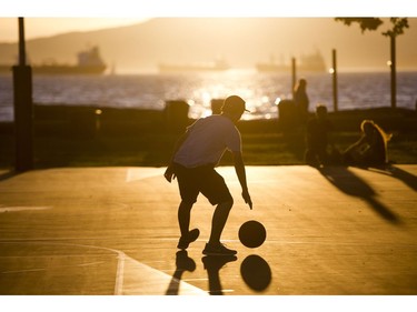 A boy dribble a basketball on the court at Kits Beach in Vancouver, B.C., June, 4, 2016.