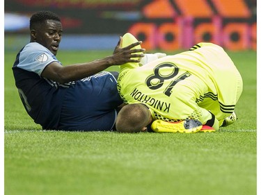 Whitecaps FC #6 Jordan Smith reaches out to New England Revolution goalie Brad Knighton after they collided.