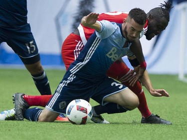 VANCOUVER June 18 2016. Whitecaps FC #31 Russell Teibert and New England Revoultion #13 Kel Kamara fall to the pitch is a regular season MLS soccer game at BC Place, Vancouver June 18 2016.( Gerry Kahrmann  /  PNG staff photo)   ( For Sun / Prov Sports ) 00043798A [PNG Merlin Archive]