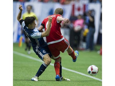 VANCOUVER June 18 2016. Whitecaps FC #11 Nicolas Mezquida tackles New England Revolution #6 Scott Caldwell in a regular season MLS soccer game at BC Place, Vancouver June 18 2016.( Gerry Kahrmann  /  PNG staff photo)   ( For Sun / Prov Sports ) 00043798A [PNG Merlin Archive]