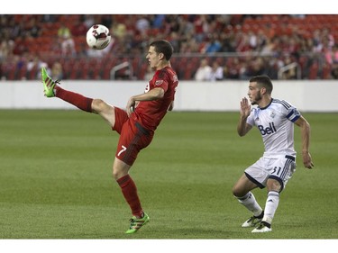 Toronto FC's Will Johnson (7) plays the ball over his head and into the Vancouver Whitecaps penalty area as Whitecaps' Russell Teibert defends during second half Canadian Cup action in Toronto on Tuesday June 21, 2016.