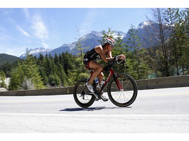 A cyclist climbs a hill near Green Lake at the 2016 Ironman Canada in Whistler, B.C.
