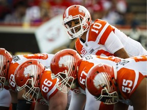 BC Lions' quarterback Jonathon Jennings, top, calls the play during first half CFL football action against the Calgary Stampeders in Calgary, Friday, July 29, 2016.THE CANADIAN PRESS/Jeff McIntosh ORG XMIT: JMC102