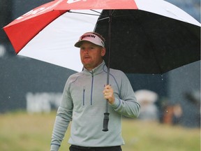 Soren Kjeldsen of Denmark uses an umbrella to shelter from the rain as he walks off the 18th green during the second round of the Open Championship at Royal Troon in Troon, Scotland, on Friday. ‘We need all four seasons in a good Open, I think,’ he said afterwards.
