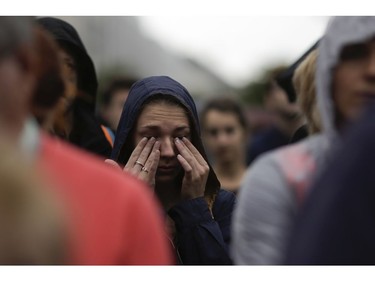 A woman weeps during an event to commemorate the victims of an attack in Nice near the French embassy in Berlin, Germany, Friday, July 15, 2016. A large truck mowed through revelers gathered for Bastille Day fireworks in Nice, killing more than 80 people and sending people fleeing into the sea as it bore down for more than a mile along the Riviera city's famed waterfront promenade.