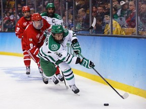 Troy Stecher of the University of North Dakota is pursued by a forechecking Boston University Terriers forward during the 2015 NCAA men’s hockey championship in Boston. The Vancouver Canucks, who signed the Richmond native as a free agent, like both his mobility and leadership skills.