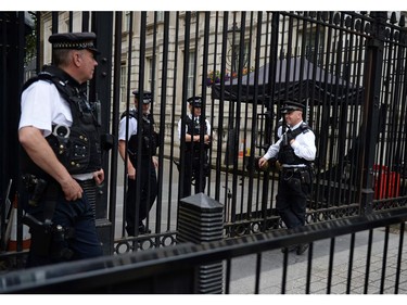 Armed British police officers stand on duty at the gates of Downing Street, the official residence of British Prime Minister Theresa May, in central London on July 15, 2016. British Prime Minister Theresa May called an emergency national security meeting Friday after the Bastille Day attack in the French city of Nice, in which at least 84 people were killed.