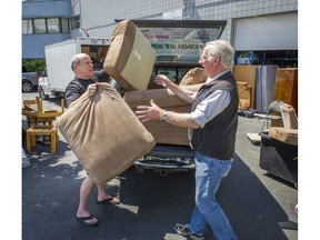 Ray Abernethy, right takes delivery of a sofa donated by Cary de Best, left at the the Helping Families In Need Society in Burnaby Wednesday July 20, 2016.