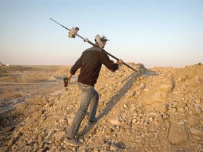 A Chinese surveyor climbs a bank of earth to take measurements at the site of a bridge project on a section of a road that will link China and Europe, that is being built near Shymkent, Kazakhstan.