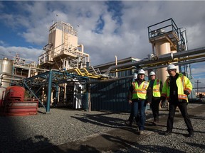 From left, Premier Christy Clark, Fortis Inc. executive vice president of western Canadian operations John Walker, and FortisBC director of gas plant operations Rolf Lyster tour FortisBC's existing Tilbury LNG facility in 2014. The rejection of a merger of a Hawaiian electric utility and a Florida company by the Hawaiian regulator has scuttled a deal to export LNG from British Columbia.