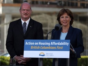 Premier Christy Clark and Finance Minister Michael de Jong, discuss amendments regarding housing issues in Greater Vancouver from the south lawn during a press conference at the Legislature in Victoria on July 25, 2016. British Columbia's real estate and home building industries say property buyers and sellers fear collapsed deals and financial losses after the province announced plans to bring in a new property transfer tax on foreign buyers.