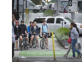Cyclists wait at the Hornby street bike lane in Vancouver. Vancouver’s Bike Score was 78/100 in a recent SFU study.