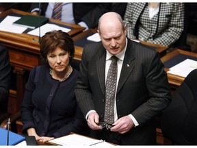 Premier Christy Clark (left) listens as B.C. Finance Minister Mike de Jong tables the provincial budget in the Legislative Assembly Tuesday, February 18, 2014 in Victoria, B.C.