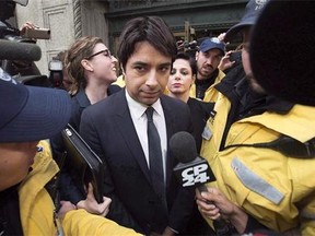 Jian Ghomeshi is escorted by police out of court past members of the media in Toronto on November 26, 2014. Ghomeshi is set to learn his fate Thursday as an Ontario judge is expected to deliver a decision in the disgraced broadcaster's closely watched sexual assault trial. THE CANADIAN PRESS/Darren Calabrese
