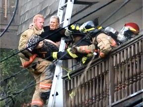 Firefighter Kit Little pulls a woman from an upper-floor unit of a North Vancouver apartment on Monday.