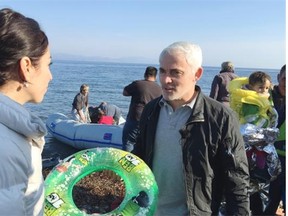 Frank Giustra among Syrian refugees on a beach on the Greek island of Lesbos.
