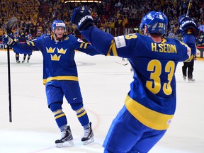 Sweden's forward Loui Eriksson (L) and forward Henrik Sedin celebrate after scoring a goal during the semi final match Finland vs Sweden of the IIHF International Ice Hockey World Championship at Globe Arena in Stockholm on May 18, 2013.