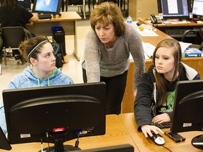 A teacher assists high school students in a coding class in Wyoming.