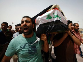 Iraqi men carry a coffin in the holy Iraqi city of Najaf on July 3, 2016, during a funeral procession for the victims of a suicide bombing that ripped through Baghdad's busy shopping district of Karrada. The blast hit the Karrada district early in the day as the area was packed with shoppers ahead of this week's holiday marking the end of the Muslim fasting month of Ramadan, killing at least 75 people in the deadliest single attack this year in Iraq's capital.     /