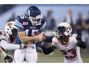 B.C. Lions' Josh Johnson (23), right, and Alex Bazzie (53) sack Toronto Argonauts quarterback Ricky Ray (15), centre, during first half CFL football action, in Toronto, on Friday, Oct. 30, 2015.