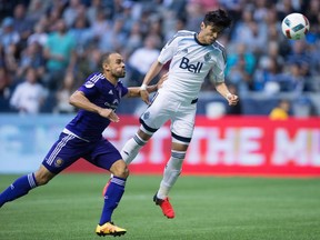 Vancouver Whitecaps' Masato Kudo, right, of Japan, gets his head on the ball but fails to score as Orlando City's Kevin Alston defends during the second half of an MLS soccer game in Vancouver, B.C., on Saturday July 16, 2016.