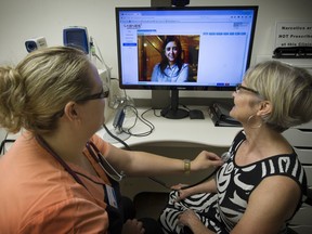 MedviewMD licensed practical nurse Liliana Faria runs reporter Erin Ellis through a health check with Dr. Kiran Singh (on screen) in Toronto. The clinic in Langley opened in June and lets doctors check   vitals from afar.