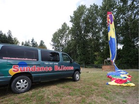 A hot air balloon is caught on a telegraph pole in a filed at Brookswood Secondary School , in Langley, BC., July 14, 2016. The balloon became snagged while trying to land too close to the pole. All six passengers were unhurt in the incident.