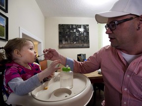 Alex Repetski, right, gives his two-year-old daughter Gwenevere oil-based medical marijuana to help control her seizures in Toronto on April 7, 2015. Parents of children suffering from epilepsy say a recent move by Canadian border agents to seize shipments of medical marijuana oil from an American company could have a catastrophic effect on their children's health. Alex Repetski uses Charlotte's Web as part of the marijuana oil he concocts at his Thornhill, Ont., home for his four-year-old daughter, Gwen, who lives with epilepsy that has left her developmentally delayed.