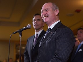 B.C. Finance Minister Mike de Jong, front, smiles as Federal Finance Minister Bill Morneau, back, listens during a news conference after reaching a deal to expand the Canada Pension Plan, in Vancouver, B.C., on Monday June 20, 2016.