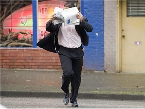 Former BC Lion Josh Boden runs across Main street, December 16th 2010, covering his face as he arrives to attend his sexual assault trial at Vancouver's Provincial court house.