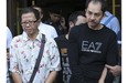 Khamla Wong, a Laos-born Canadian drug suspect, right, and his Chinese accomplice, Fangyong Saeyang, are escorted by police from a condominium on Rama IX Road Bangkok.