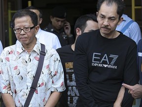 Khamla Wong, a Laos-born Canadian drug suspect, right, and his Chinese accomplice, Fangyong Saeyang, are escorted by police from a condominium on Rama IX Road Bangkok.