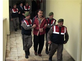 Turkish paramilitary police officers escort Syrian smugglers Muwafaka Alabash, front, and Asem Alfrhad, rear. for their trial in Bodrum, Turkey, Friday, March 4, 2016.