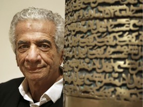 In this Feb. 9, 2015 file photo, Iranian artist Parviz Tanavoli stands near a detail of his sculpture "Poet Turning into Heech," at the Davis Museum on the campus of Wellesley College in Wellesley, Mass. Tanavoli says he has been barred from leaving the country while trying to travel to London.